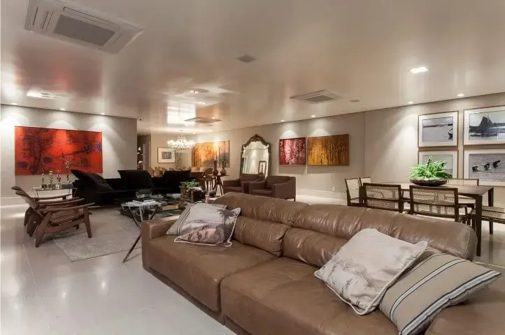 Sala ampla com sofá de couro marrom claro Projeto de SQ Arquitetos Associados