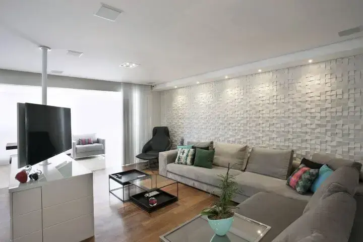 Sala de TV com sofá em L cinza e decoração clara Projeto de Katia Llaneli
