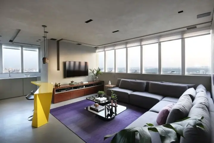 Sala de TV com sofá em L cinza e tapete roxo Projeto de Box 14
