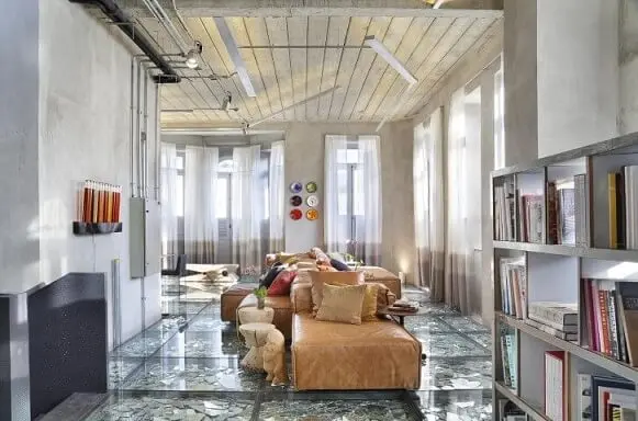 Sala de estar ampla com sofá de couro longo marrom bem claro Projeto de Gisele Taranto