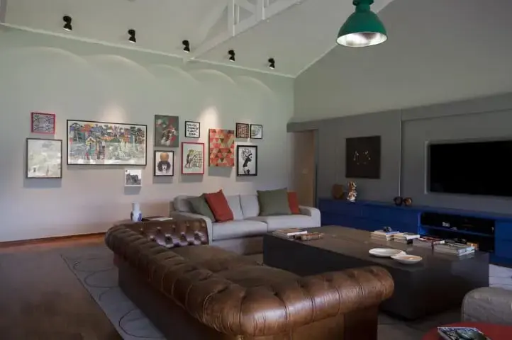 Sala de estar ampla com sofá de couro marrom com sofá cinza e mesa de centro preta Projeto de AMC Arquitetura
