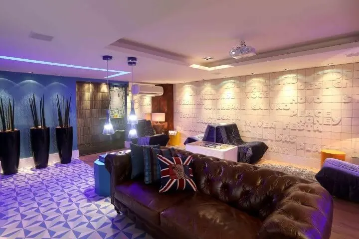 Sala de estar ampla com sofá de couro marrom e pendentes ao lado Projeto de Guilherme Galvão