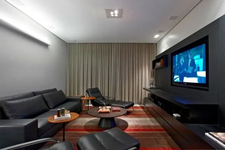 Sala de estar com sofá de couro e poltronas do mesmo material Projeto de Graziella Nicolai