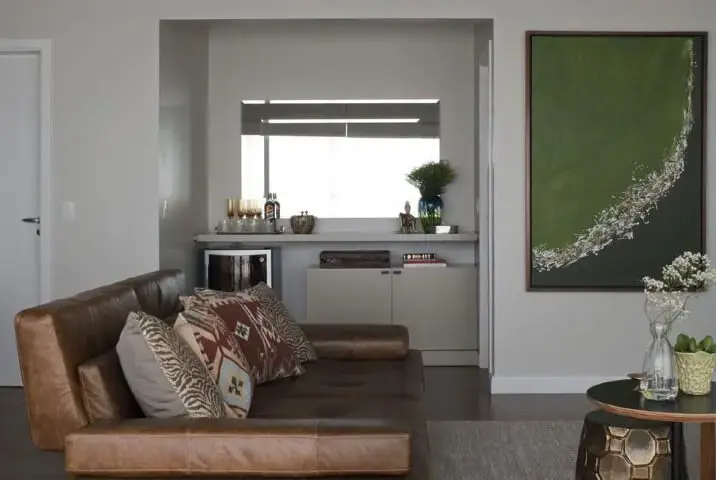 Sala de estar com sofá de couro marrom e com bar no canto Projeto de D2N Arquitetura