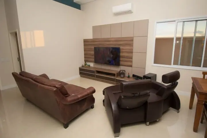 Sala de estar com sofá de couro marrom e sofá retrátil Projeto de SA Engenharia e Arquitetura