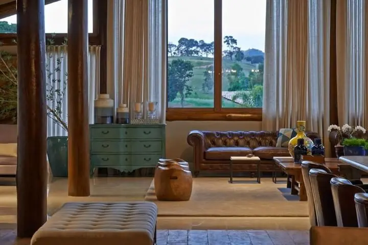 Sala de estar com sofá de couro marrom estilo capitonê Projeto de Glaucia Britto