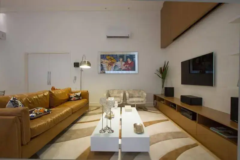 Sala de estar com sofá de couro na cor ocre Projeto de Studio KZA