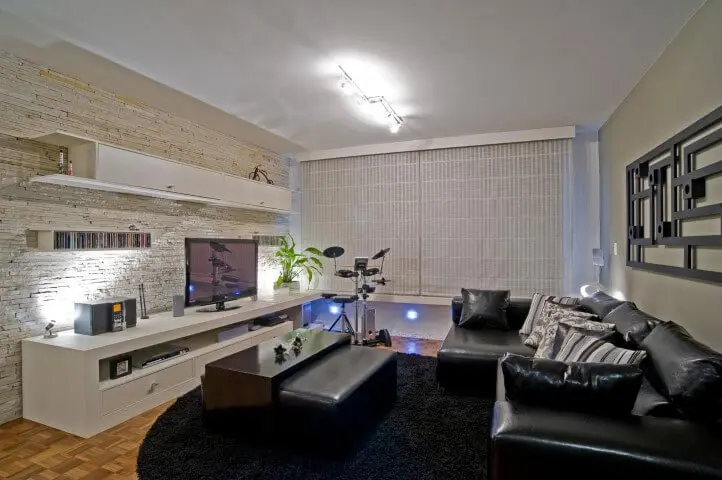 Sala de estar com sofá de couro preto com chaise Projeto de Patricia Azoni