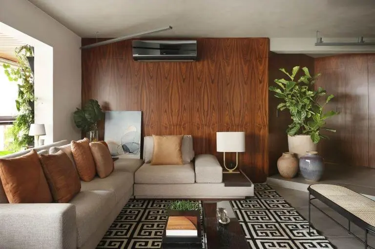 Sala de estar com sofá em L bege e tapete geométrico Projeto de Quattrino Arquitetura