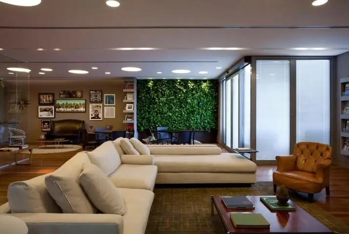 Sala de estar com sofá em L branco e poltrona marrom de couro Projeto de AMC Arquitetura