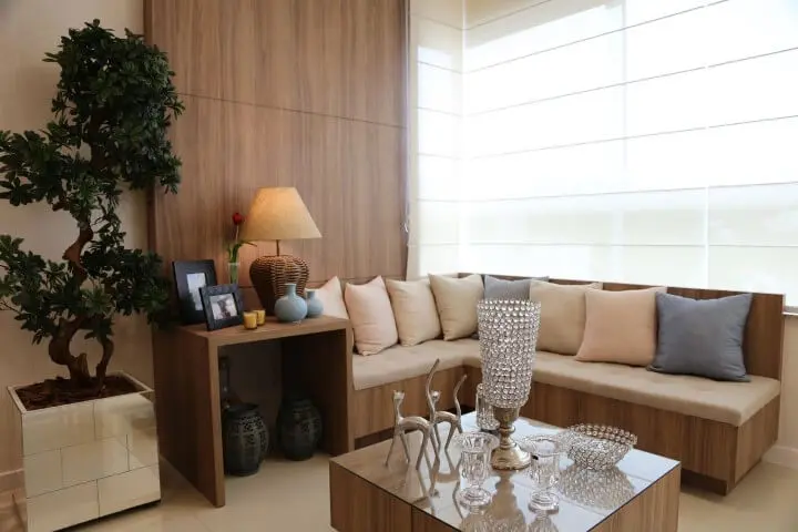 Sala de estar com sofá em L embutido e mesa de centro combinando Projeto de Fernanda Pereira