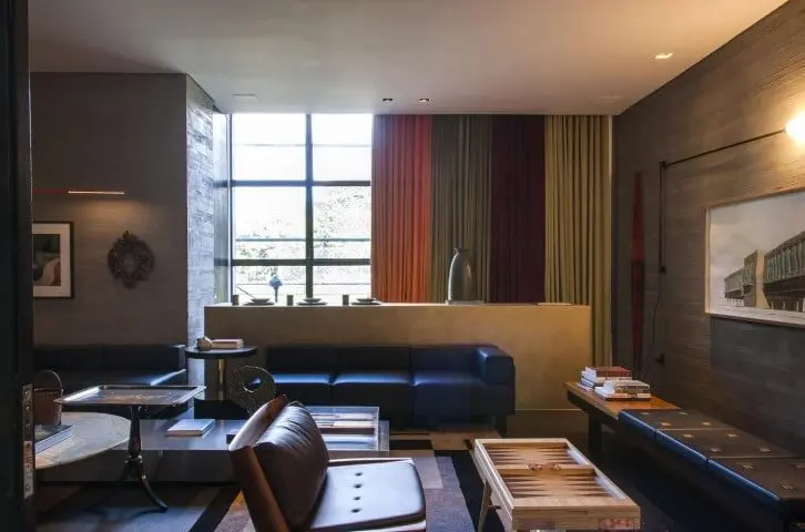 Sala de estar moderna com cortinas coloridas e sofá de couro preto Projeto de Casa Cor 2016