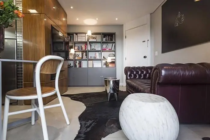 Sala de estar moderna com sofá de couro escuro Projeto de Mauricio Karam