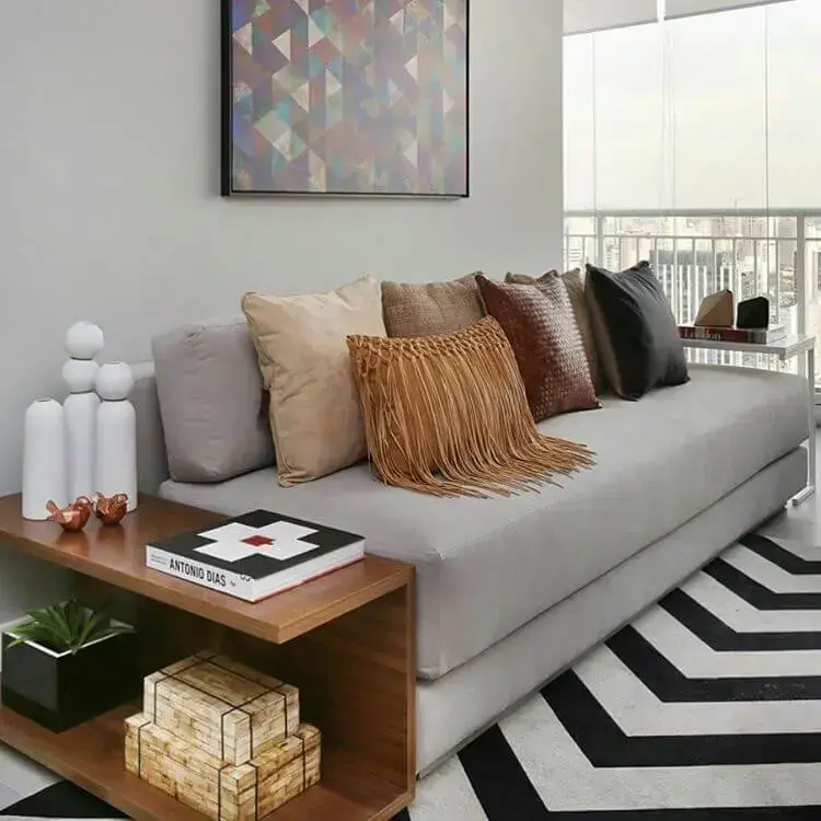 Sala de estar pequena com almofadas de estilos variados em sofá cinza Foto de We Heart It