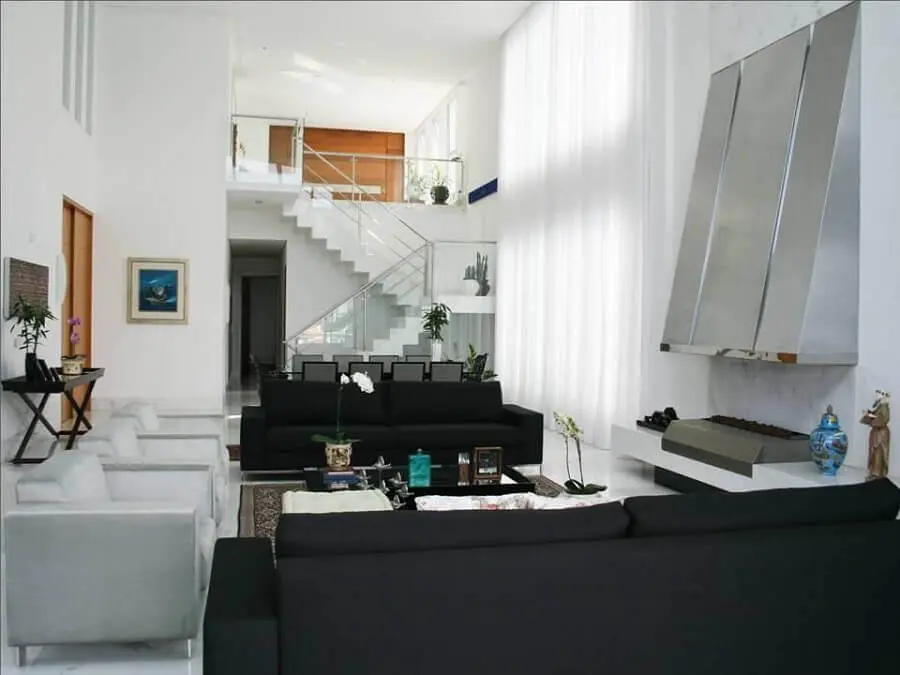 casa ampla decorada com sofá preto e mezanino Foto Luciane Leal
