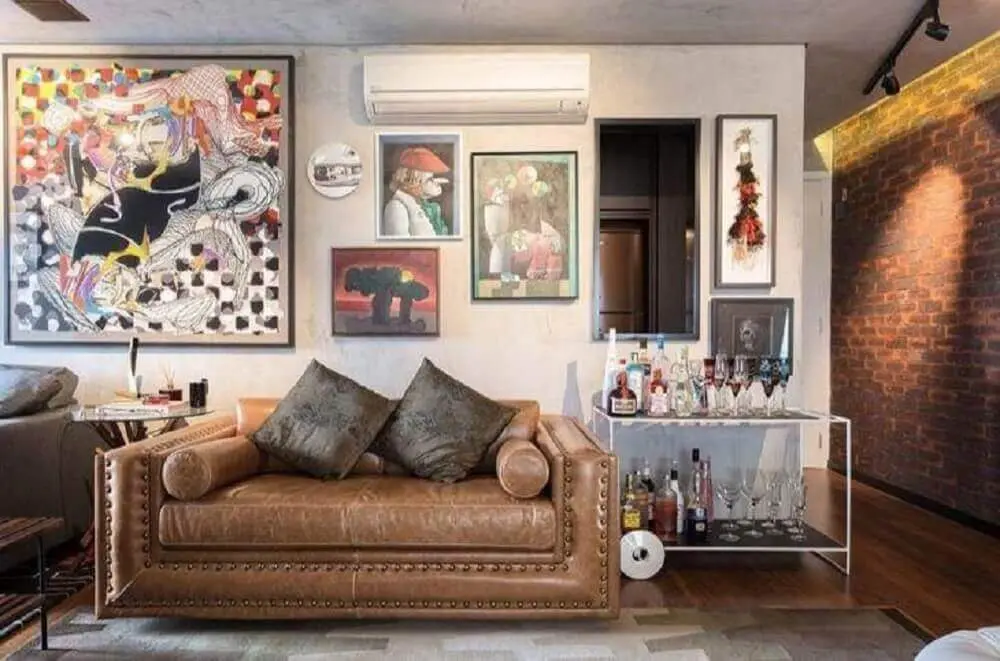 decoração com muitos quadros e sofá de couro para sala pequena Foto Clarice Semerene
