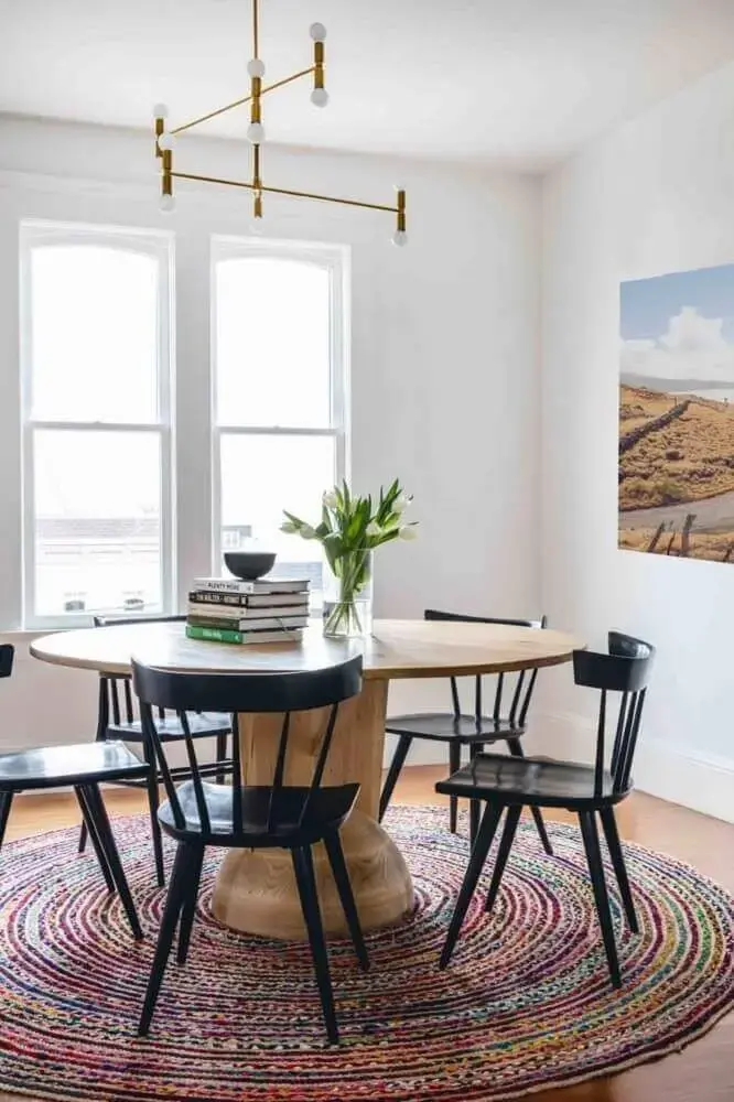 decoração com tapete redondo para sala de jantar com mesa de madeira e cadeiras pretas Foto Refined Haystack