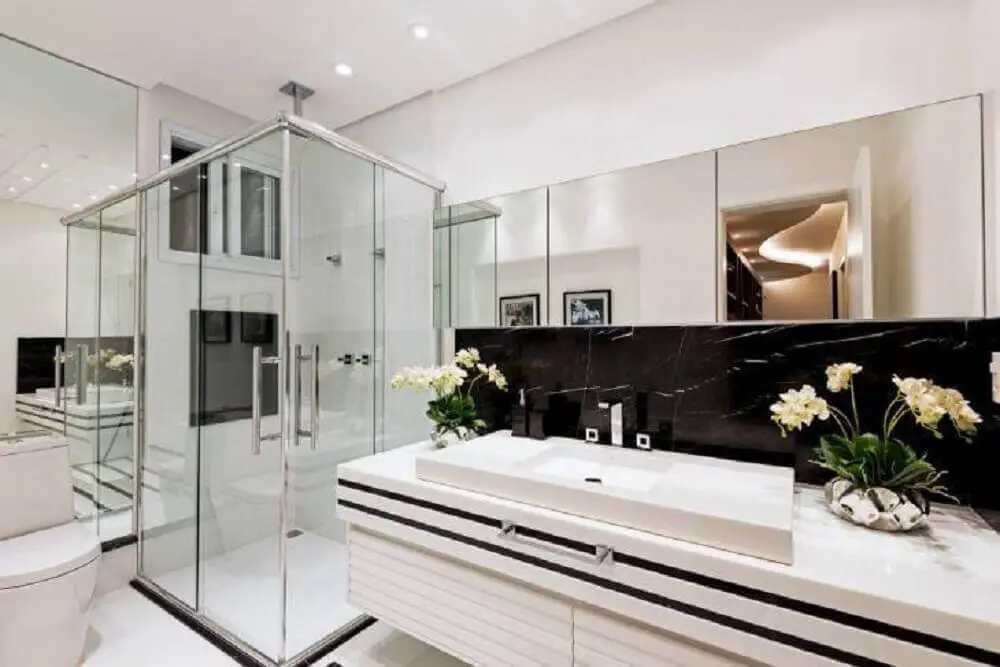 decoração de banheiro preto e branco com espelheira box de vidro e bancada de pedra nanoglass Foto Iara Kílaris