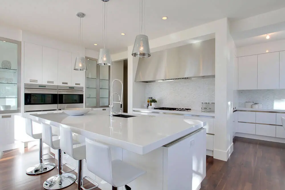 decoração de cozinha toda branca com ilha de nanoglass branco pendentes modernos e exaustor de inox Foto Kitchen Decor