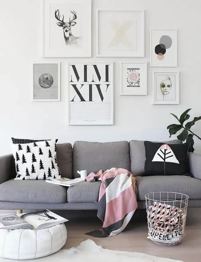 decoração estilo escandinava para sala com quadros na parede e manta para sofá com estampa em tons de rosa branco e cinza Foto DecoStore