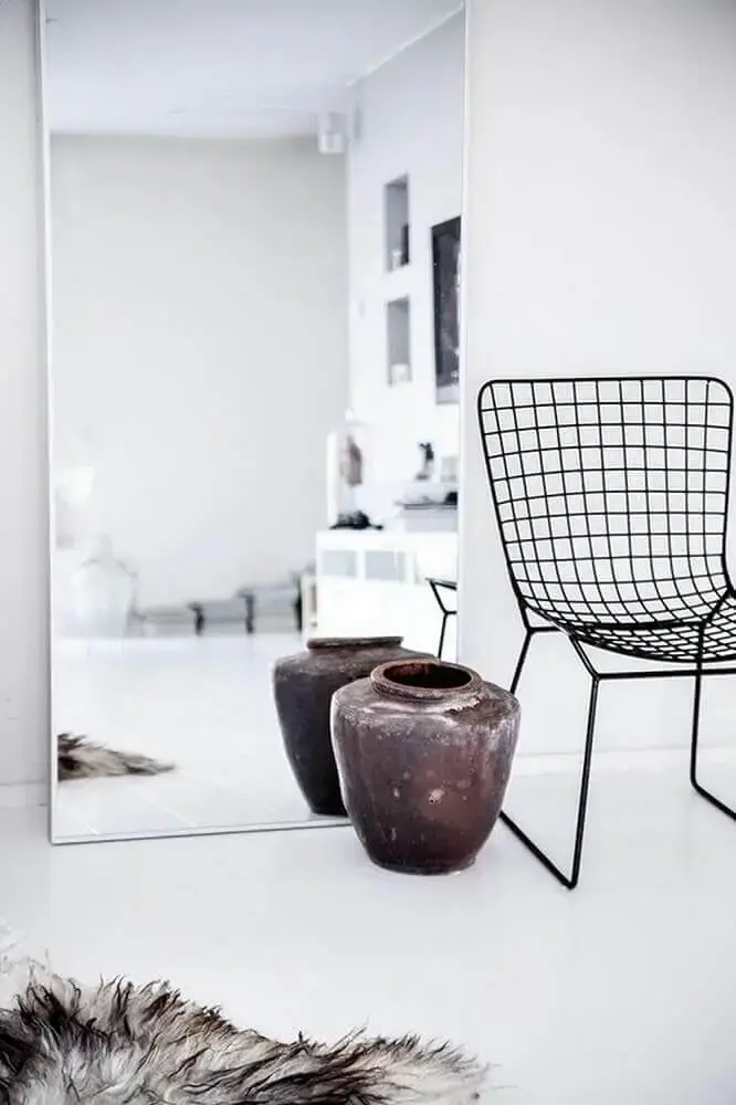 decoração minimalista com espelho grande apoiado no chão e cadeira de aramado Foto Plan Reforma
