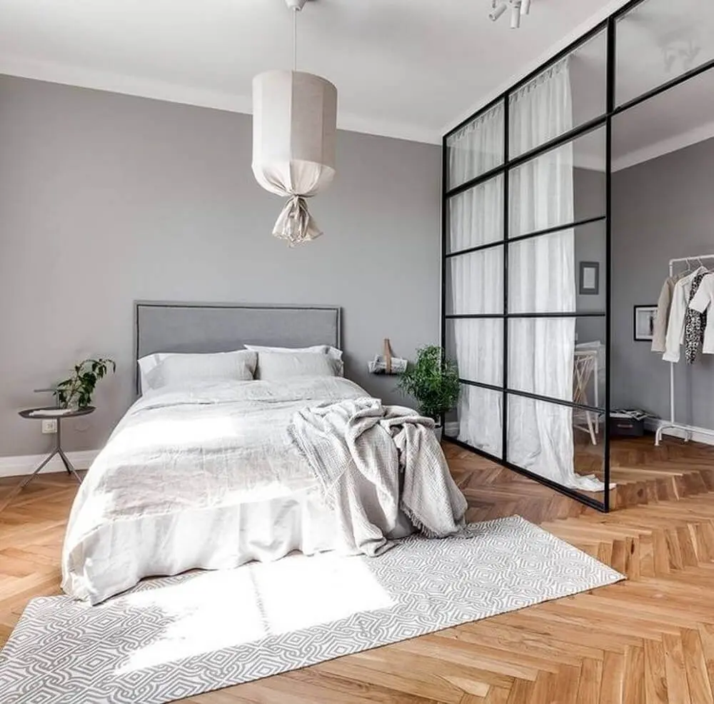 decoração minimalista para quarto com closet com parede divisória de vidro e piso de madeira Foto The Holk