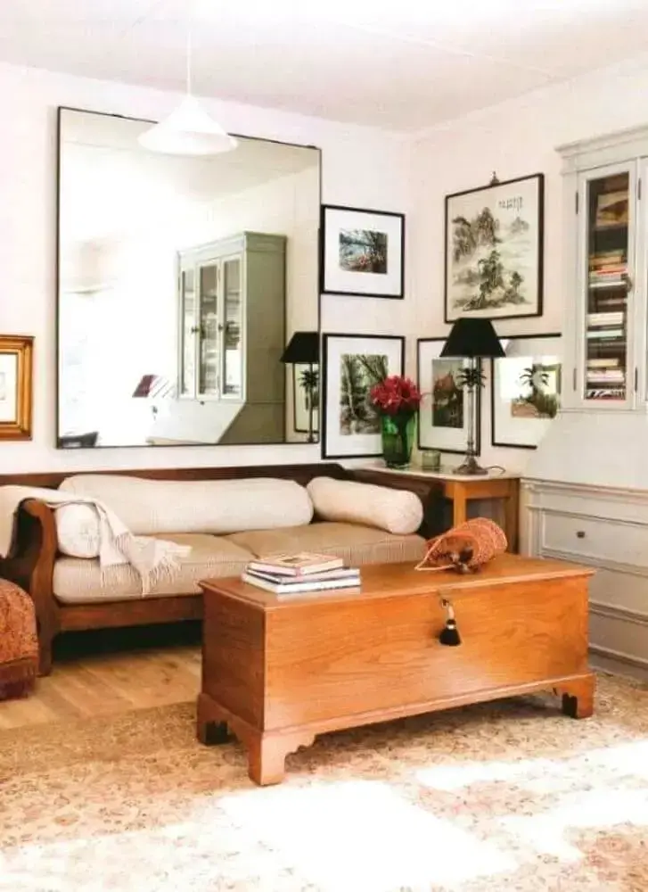 decoração para sala de estar com móveis de madeira e espelho grande de parede Foto Emily Garrison