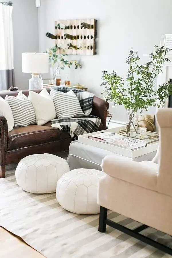 decoração para sala pequena com puff redondo branco e manta xadrez para sofá de couro marrom Foto FeedPuzzle