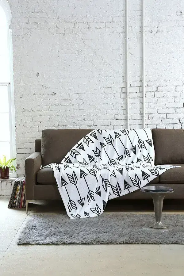 decoração simples para sala com parede de tijolinho branco com modelo estampado de manta para sofá Foto Pinterest