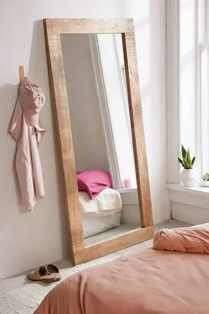 quarto decorado com espelho grande com moldura de madeira apoiado no chão Foto Sincerely Laura Leigh