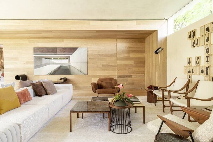 sala de estar ampla decorada na cor marfim com revestimento de madeira para parede Foto Caio Prado Arquitetura e Interiores