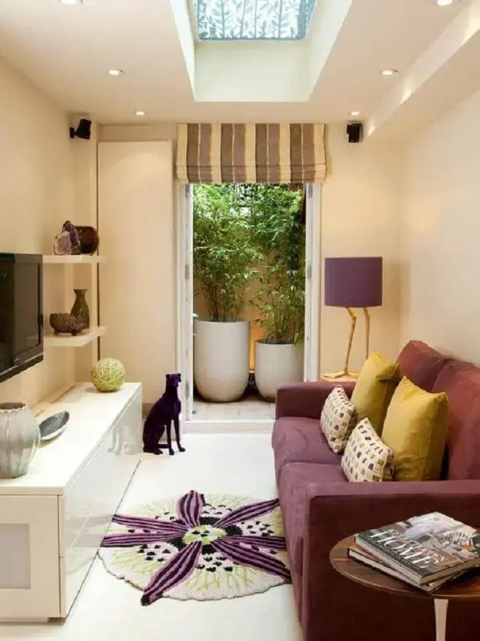sala de estar pequena decorada com parede marfim e sofá na cor marsala Foto Pinterest