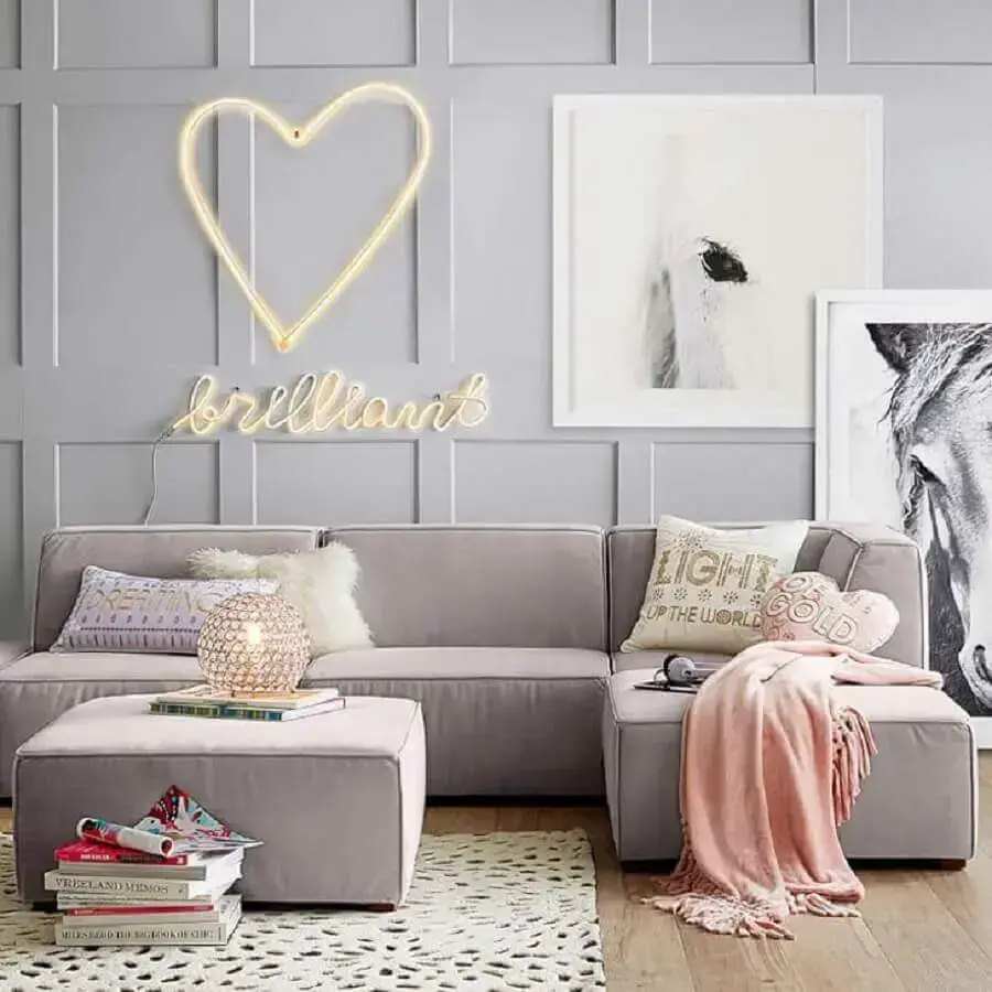 sala decorada com quadro grande e manta rosa para sofá de canto Foto Mumbly World