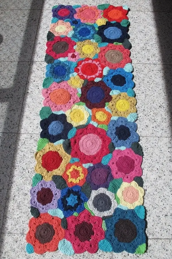 A passadeira de crochê com flores traz alegria para a decoração