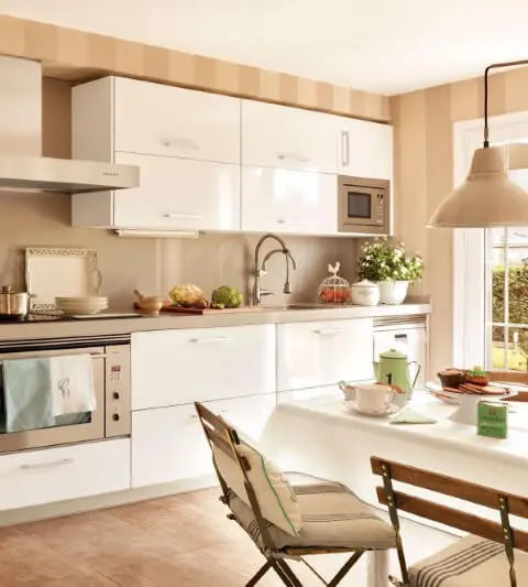 Cozinha com paredes em cor de palha e armários brancos Foto de El Mueble
