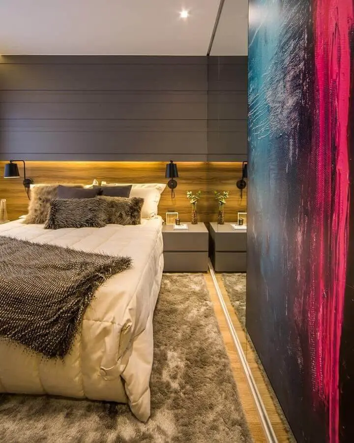 Decoração moderna com tapete para quarto masculino planejado com luminária de parede e revestimento de madeira Foto Claudia Albertini Arquitetura