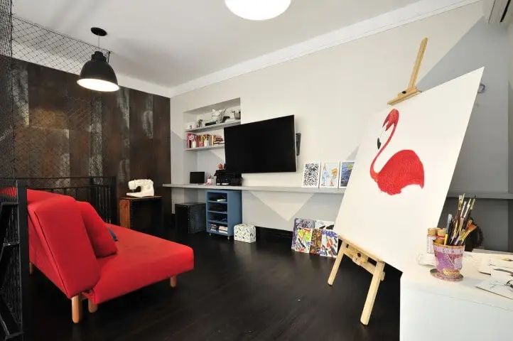 Home office com piso vinílico escuro e decoração colorida Projeto de Ana Cristina Nigromalta