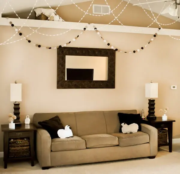 Sala de estar com parede cor palha e móveis em tons escuros Foto de Cultura Mix