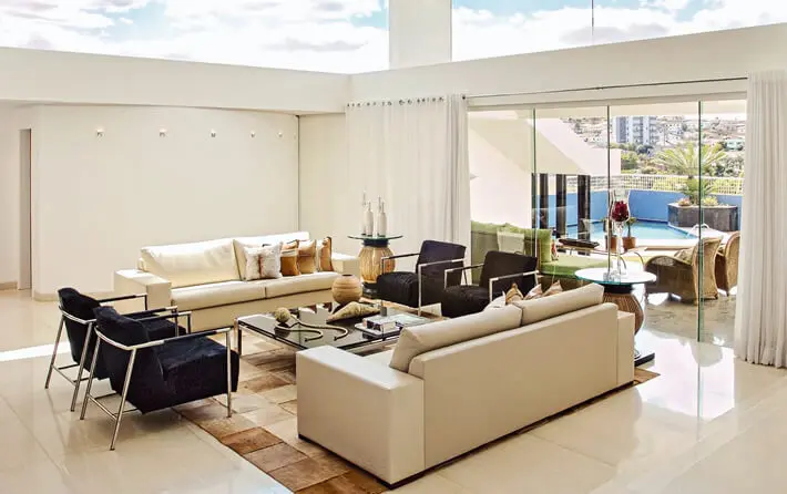 Sala de estar com parede cor palha e poltronas pretas Foto de Modernidade Móveis