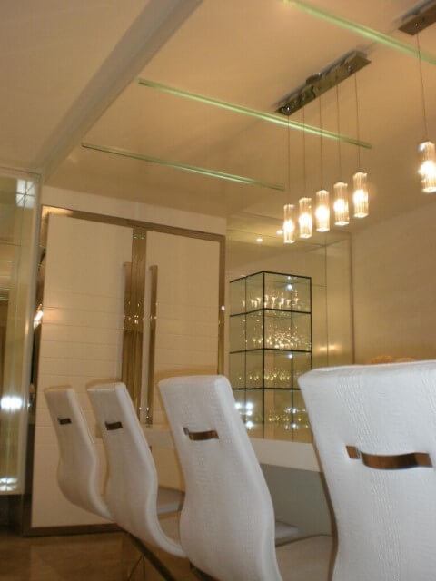 Sala de jantar sofisticada com cristaleira moderna de vidro Projeto de Larissa Vinagre