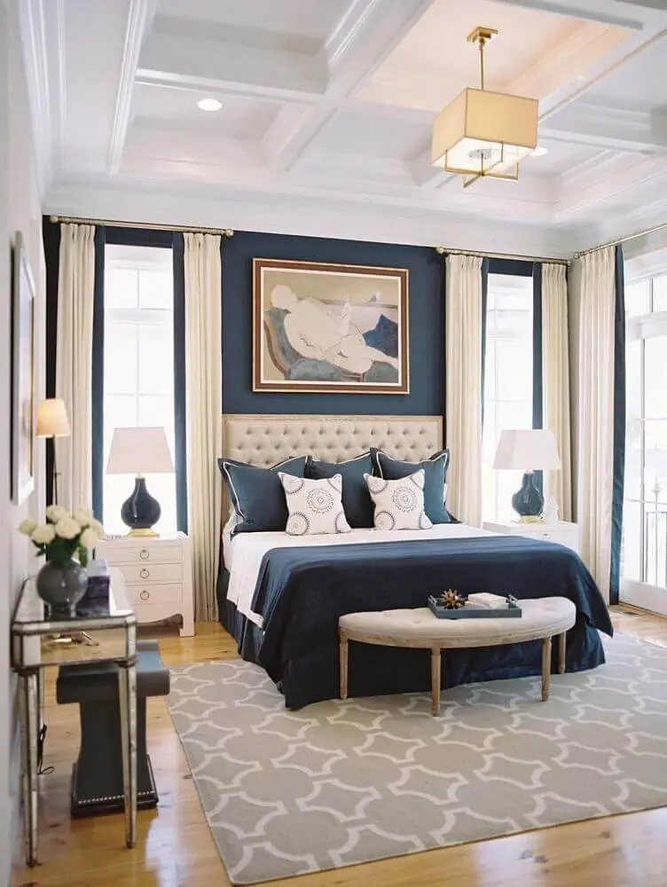 decoração com estilo clássico com tapete para quarto de casal com parede azul marinho e cabeceira capitonê Foto Buyer Select