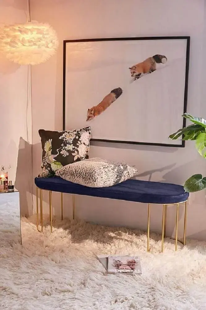 decoração com tapete felpudo branco e banco azul marinho com pernas douradas Foto Urban Outfitters