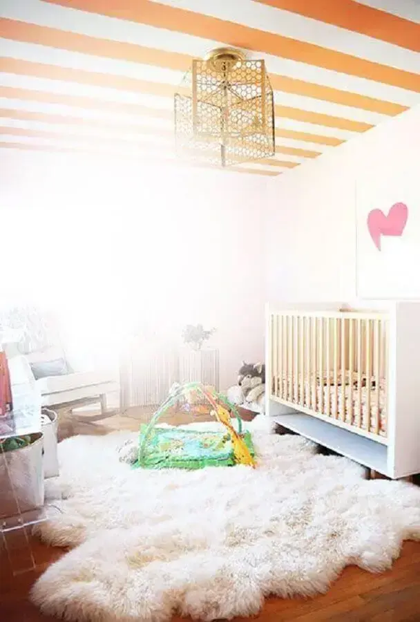 decoração com tapete felpudo branco para quarto de bebê com teto listrado branco e laranja Foto The Glow