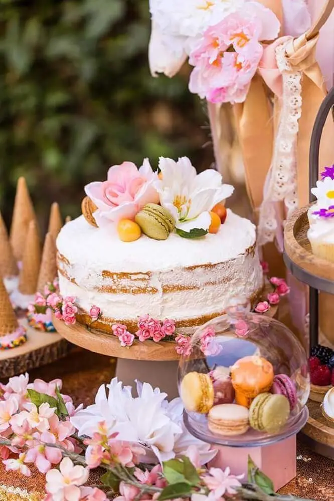 decoração romântica com bolo de casamento simples com chantilly e flores Foto Brit + Co