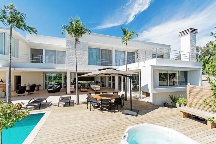 Casa moderna branca com piscina com deck e hidro Projeto de Jannini Sagarra Arquitetura