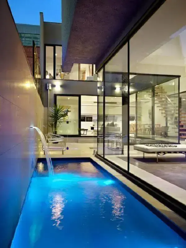 Cascata para piscina embutida no muro com iluminação