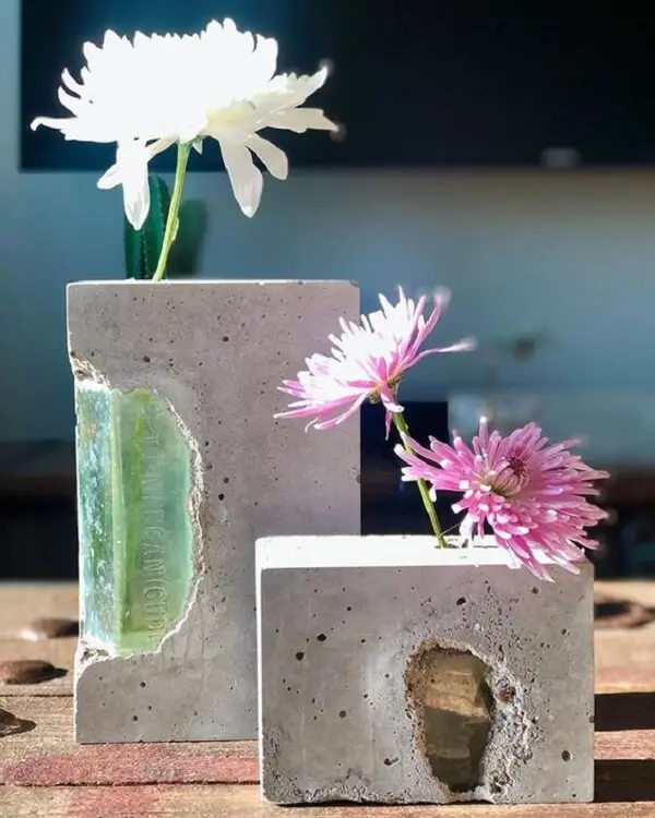 O vaso de cimento apresenta uma decoração rústica