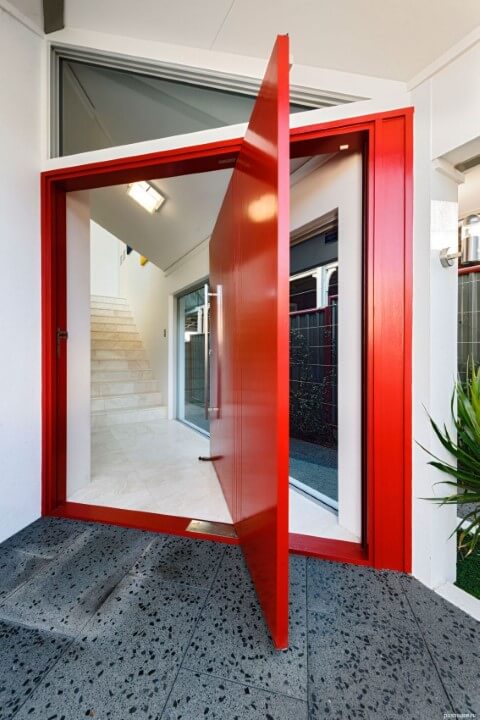Porta pivotante vermelha com portal vermelho Foto de Pos House