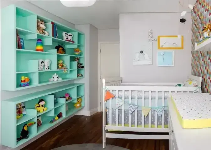 Quarto de bebê menino com estante verde com nichos com brinquedos Projeto de Anna Maria Parisi
