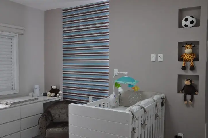 Quarto de bebê menino com parede cinza e papel de parede listrado Projeto de Claudia Breias